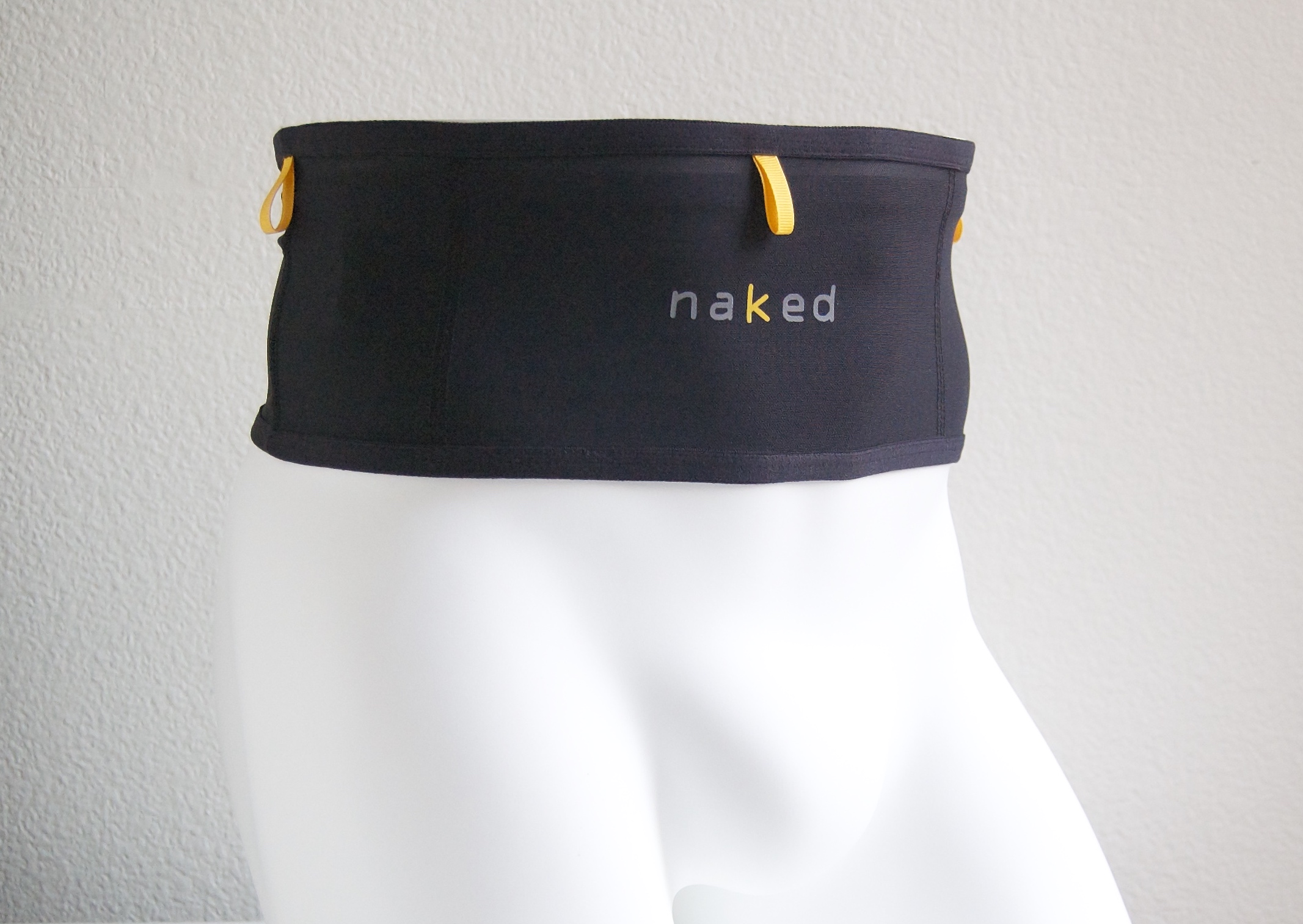 the original naked running band in black with three yellow pull tabs and the naked wordmark