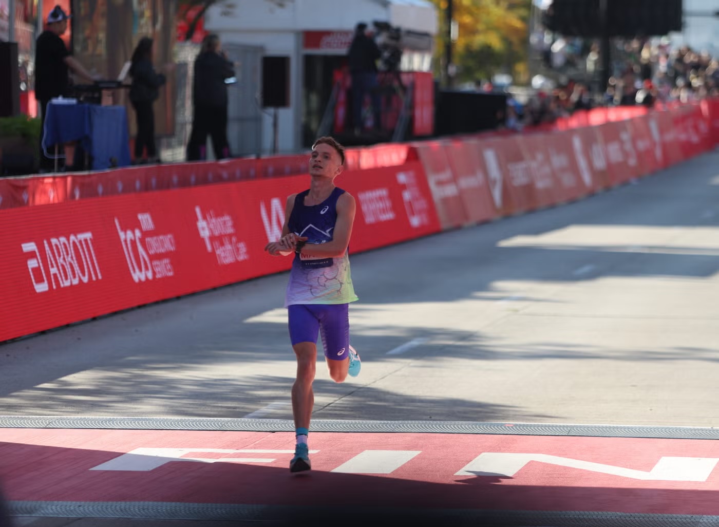 vinny mauri stopped on the course at the 2026 chicago marathon, stretching his hamstring